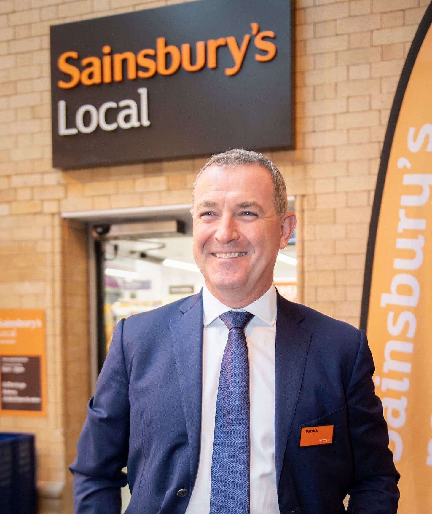 Smart Charge director Patrick Dunne standing in front of Sainsbury's local