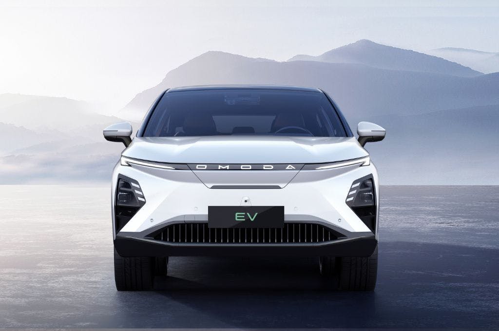 A dramatic image of the new Omoda 5 electric vehicle on a flat ground with misty mountains in the background