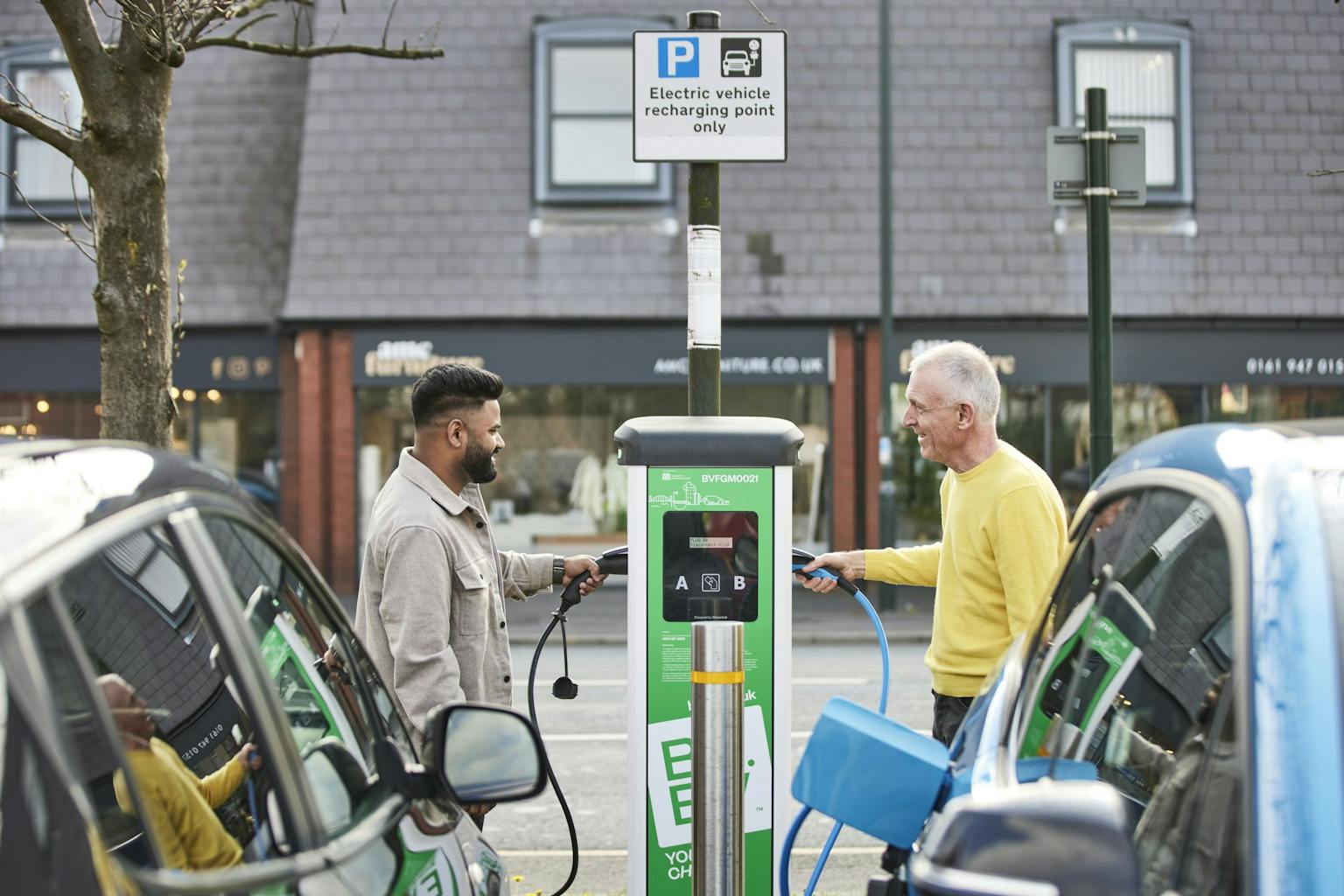 Two men using a Be.EV charging point at the same time