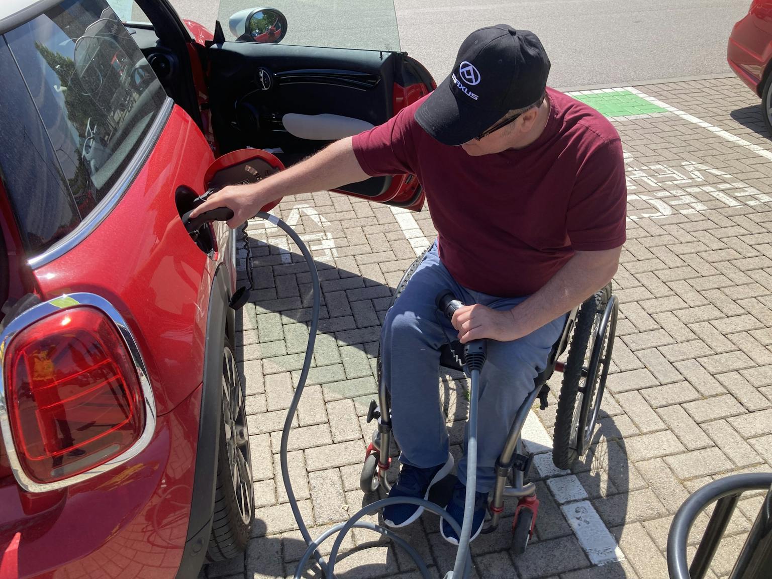 photo of man, roger warner, charging EV while in wheelchair