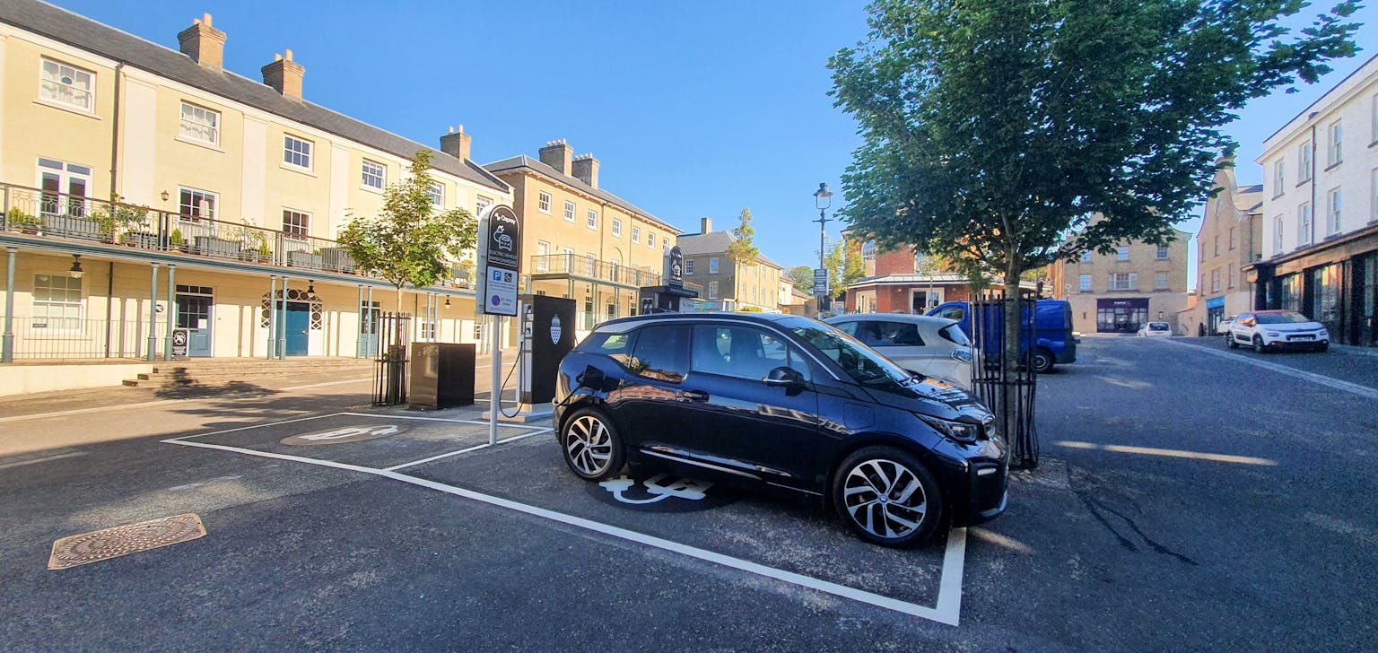 image shows electric cars charging at Osprey charging site inbetween houses